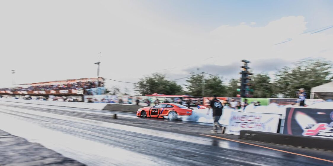 Orange race care con el máximo rendimiento del motor en una pista mojada