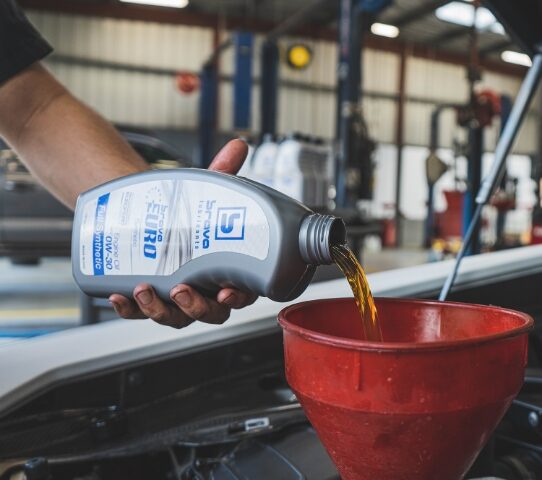 Man pouring Brava Euro oil into engine