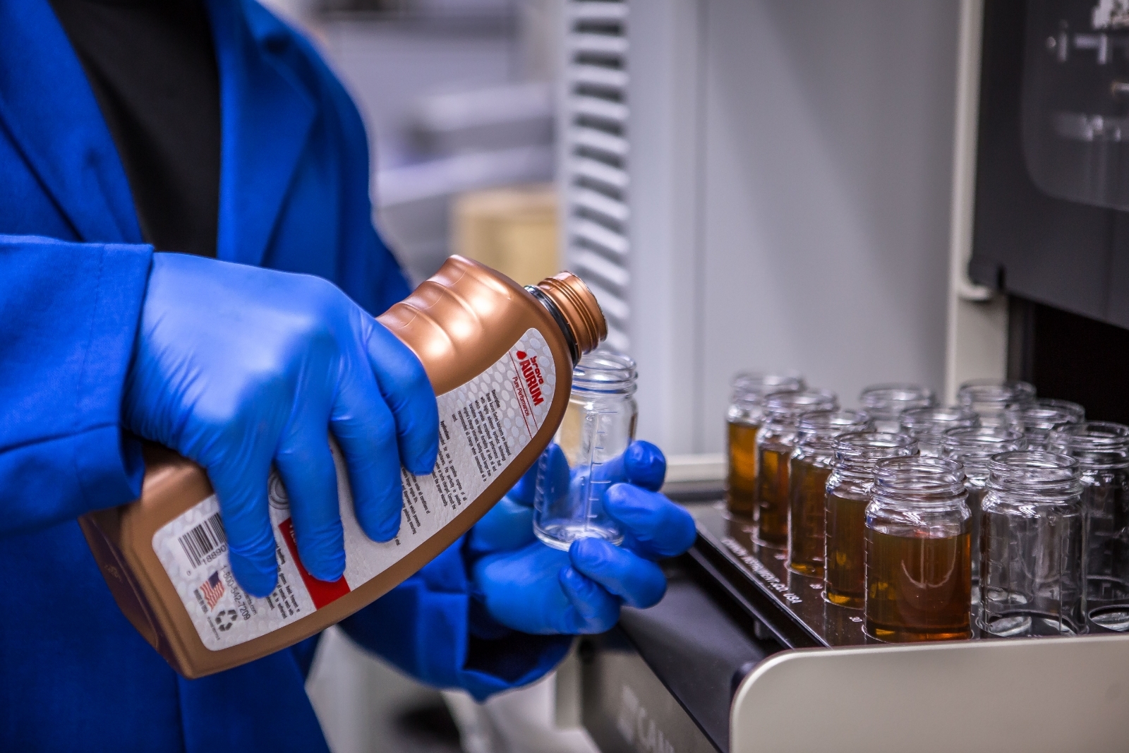 Técnico de laboratorio vertiendo brava Aurum en un vaso de precipitados