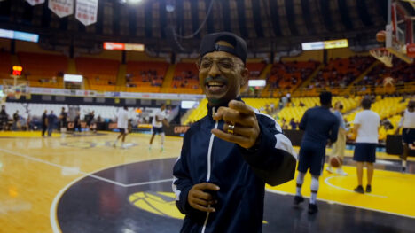 Man standing on the basketball court pointing to camera